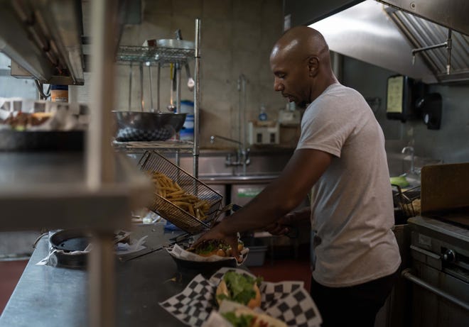 Shawn Thomas, founder of Go Vegan Philly, is about to pour fresh fries onto a tray at his Wilmington restaurant on Aug. 29.