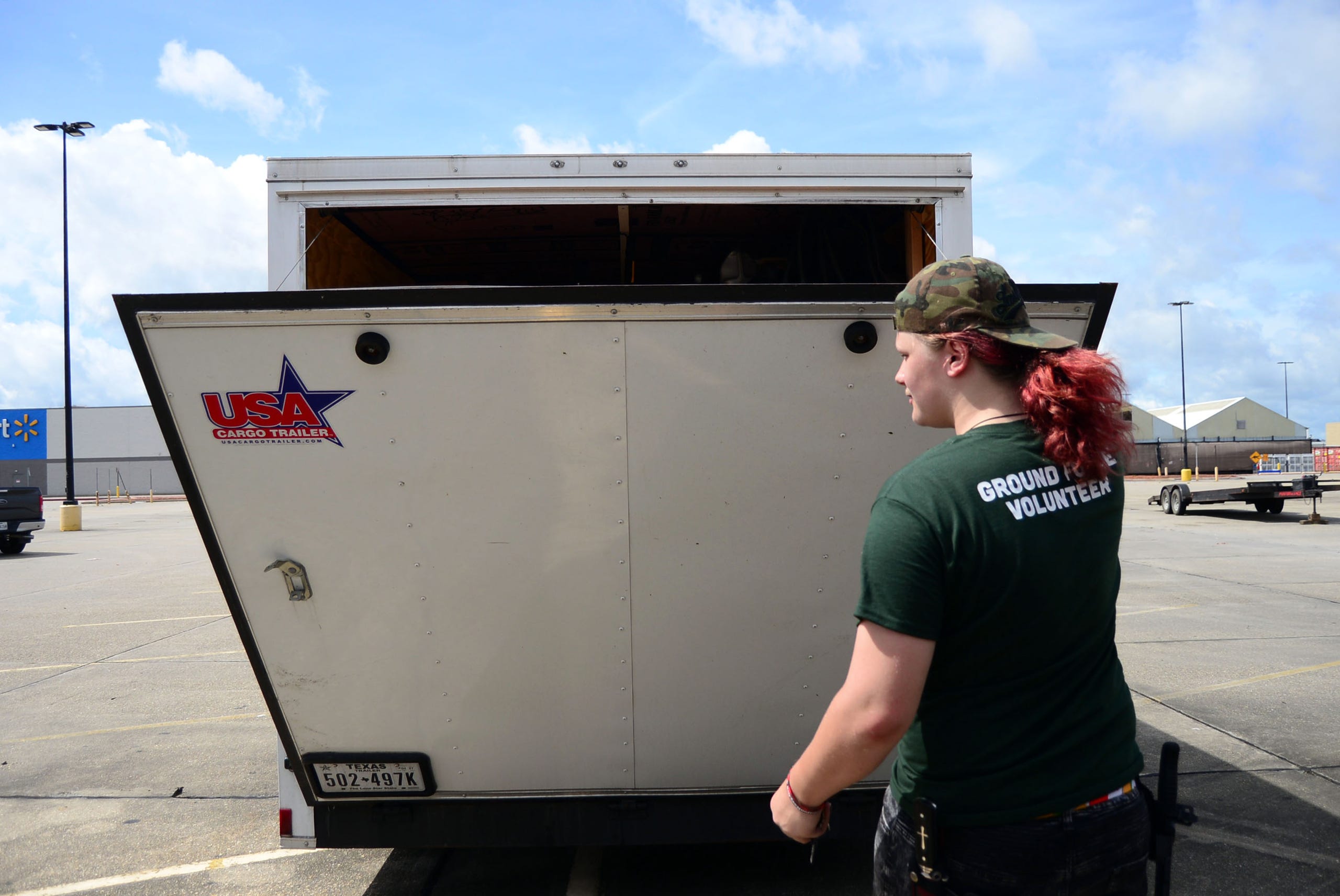 A teenage volunteer with the Cajun Navy Foundation's Ground Force opens the back of a Cajun Navy trailer containing supplies to distribute to residents in Houma.