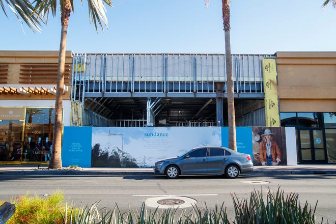 A shopper walks past a building under renovation for a Sundance store in Palm Desert, Calif., on August 26, 2021. Sundance, founded by Robert Redford, started as a catalog for clothing, footwear and accessories as well as home decor and furnishings. When it opens in mid-November, the El Paseo location will be the only Sundance store in California.