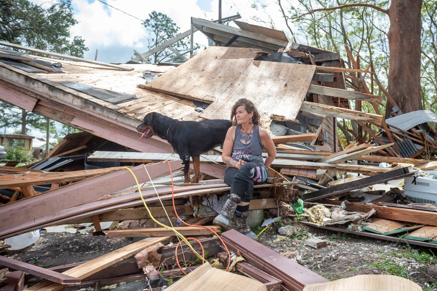 Fran Tribe and her dog Dave sit outside home destroyed by Hurricane Ida in Houma, LA. Monday, Aug. 30, 2021. 