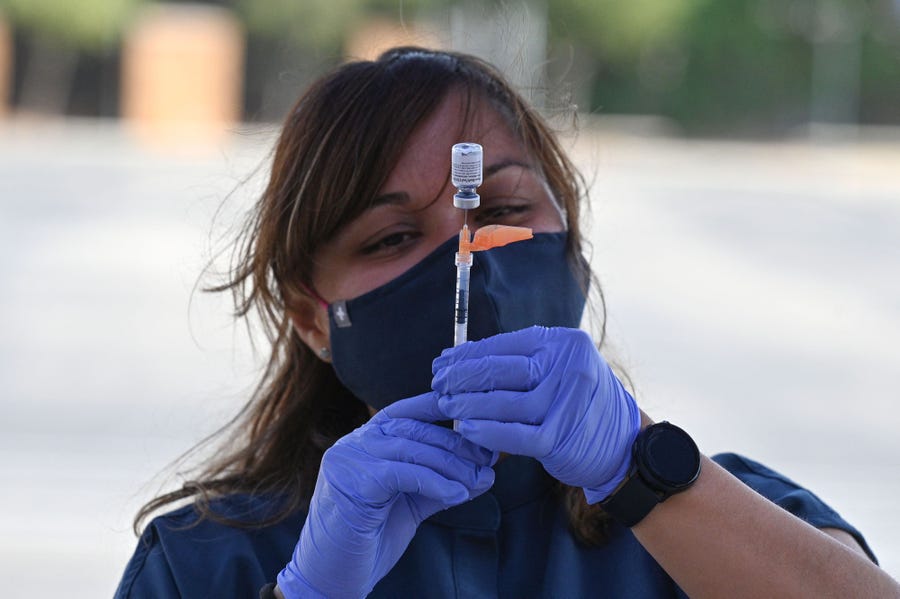 A nurse fills a syringe at a pop-up vaccine clinic in the Arleta neighborhood of Los Angeles on Aug. 23.