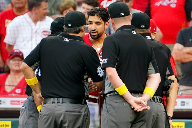 Cincinnati Reds right fielder Nick Castellanos (2), center, and Cincinnati Reds manager David Bell (25) talk with the umpire crew after Castellanos hit a grand slam home run in the second inning of a baseball game against the St. Louis Cardinals, Wednesday, Sept. 1, 2021, at Great American Ball Park in Cincinnati. The umpires inquired on the status of CastellanosÕ bat, noticing a chip in the bat.