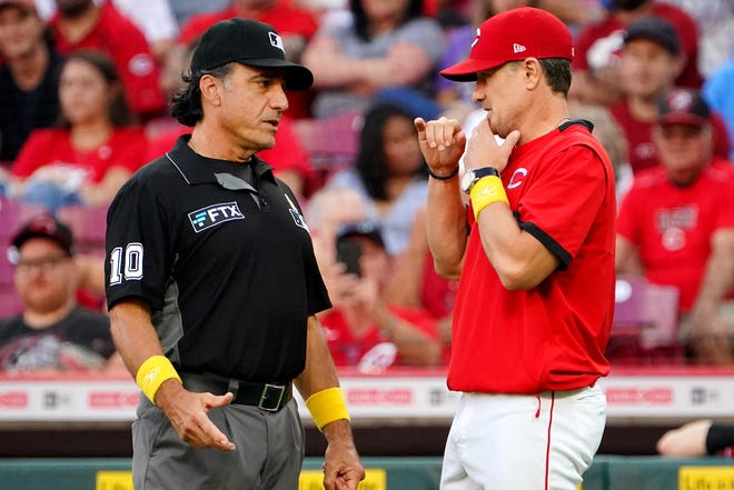 Cincinnati Reds manager David Bell (25) talks with umpire Phil Cuzzi (10) after Cincinnati Reds third baseman Eugenio Suarez (7) home run was ruled a double in the first inning of a baseball game against the St. Louis Cardinals, Wednesday, Sept. 1, 2021, at Great American Ball Park in Cincinnati.