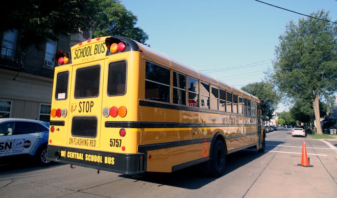A school bus passes by Rogers Street Academy on the first day of school on Thursday, Sept. 2, 2021.