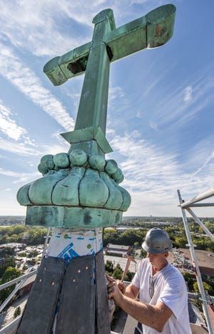 At 170 feet in the air Isaac Rader replaces the slate tiles on the east steeple of St. Joseph Catholic Church in Louisville. Sept. 3, 2021