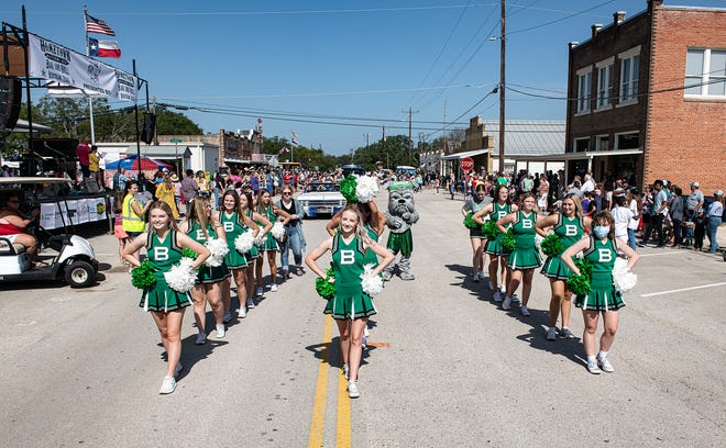 Members of the Burnet High School cheerleading team march in the Grand Parade during the 44th annual Oatmeal Festival on Saturday. The school district has closed all schools for two days because of COVID-19.