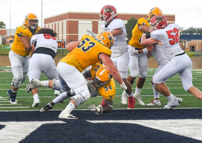 Augustana's David Addo, lower center, dives under teammate Kevin Hartman to score a touchdown in their first home football game of the season on Saturday, September 4, 2021 at Kirkeby-Over Stadium in Sioux Falls.