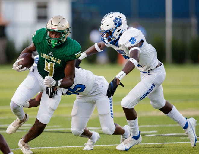 Lincoln's Cedric Madry Jr. (4) avoids tackles as he runs down the field. The Lincoln Trojans and Godby Cougars face off at Gene Cox on Friday, Sept. 3, 2021. 