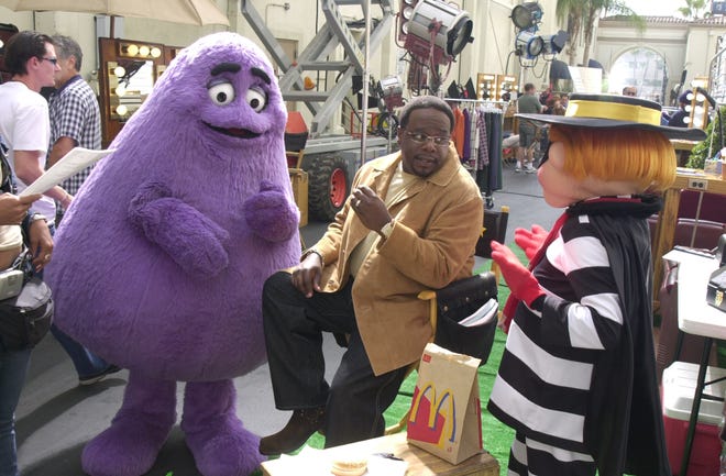 From left, Grimace and Cedric the Entertainer talk with The Hamburgler during a scene of  a McDonald's commercial in 2002.
