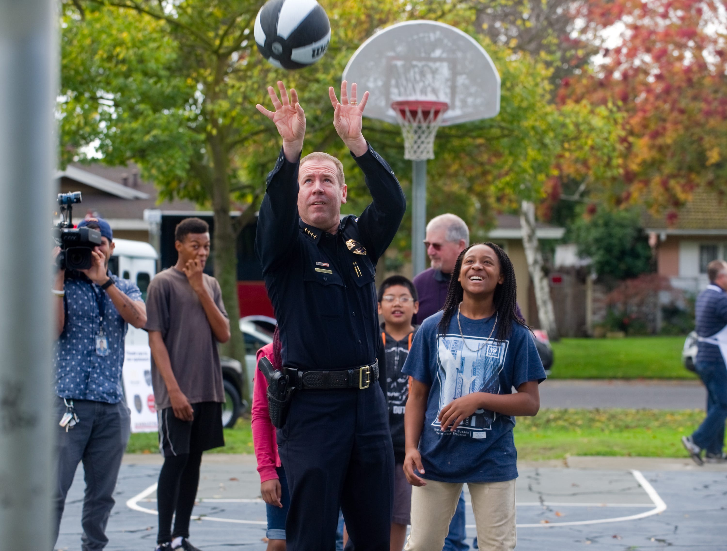 Stockton Police Chief Eric Jones shoots free throws with area children at the department's community barbecue at Loch Lomond Park in north Stockton on Nov. 21, 2016. Police are now going “much deeper into the type of community policing we do,” Jones said, and activities like these play a large part.