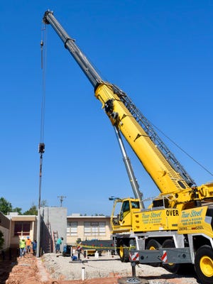 A crane moves large concrete panels for the new Will Rogers Elementary School safe room.