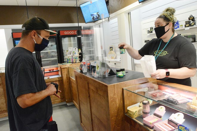 Laci Vitiello, dispensary technician at Fine Fettle medical marijuana dispensary in Willimantic, shows items bought by medical marijuana patient Andrew O'Brien of Storrs.