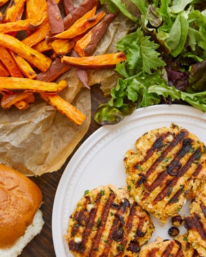 Salmon burgers can be paired with sweet potato fries for an easy dinner.