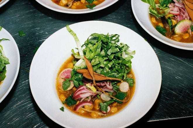 Pozole, garnished with cabbage, onions and radishes.