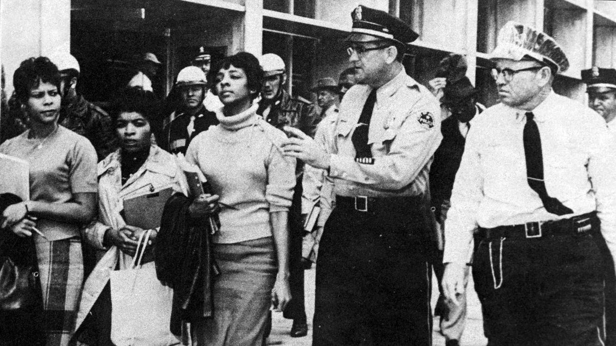 Police escort a group of black students from the Jackson Public Library in Mississippi March 27, 1961, a few minutes after they entered the main library building restricted for the use of whites.