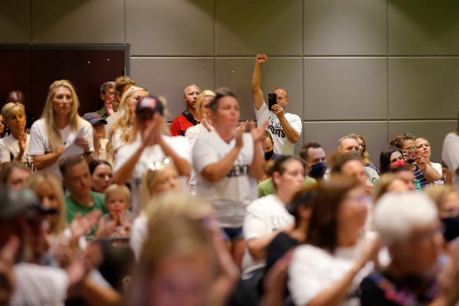 Those opposed to the Edmond Public Schools mask requirement cheer after a public comment during a public a school board meeting in Edmond, Okla., Thursday, Sept. 9, 2021.