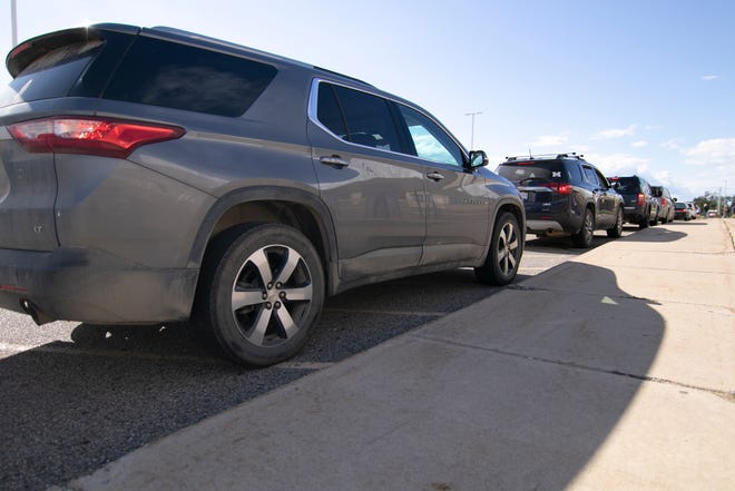Cars line up at the entrance to Fowlerville High School Thursday, Sept. 9, 2021 for a Gleaners food distribution event.