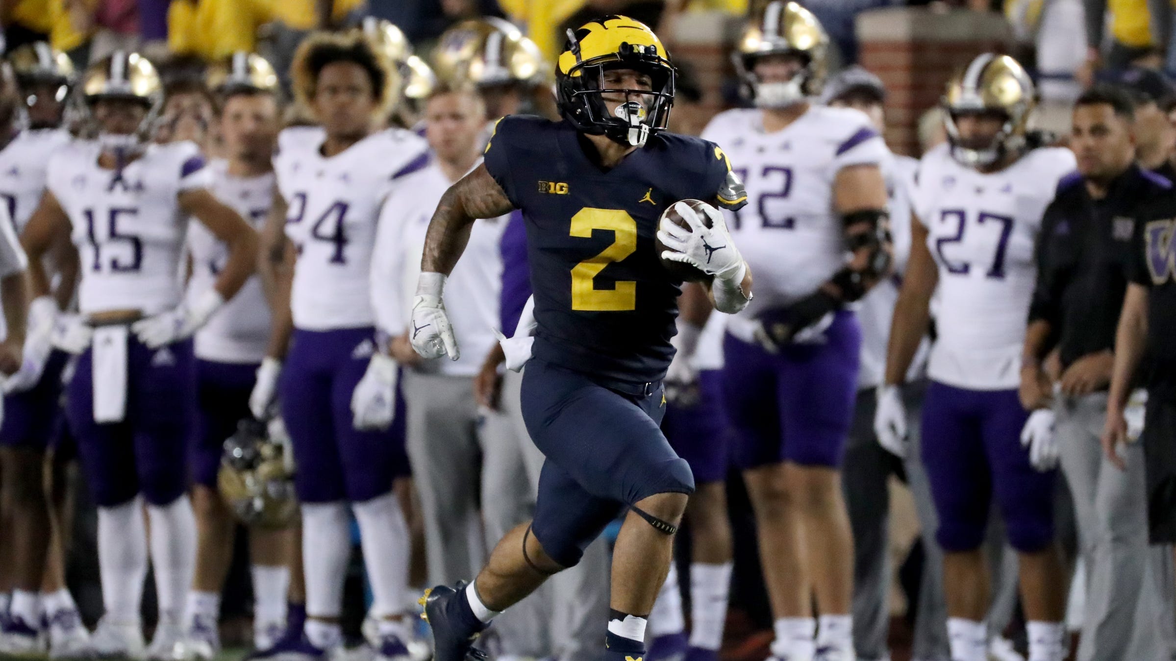 Michigan Wolverines running back Blake Corum (2) is led by Washington Huskies defensive back Kamren Fabiculanan (31) for a touchdown on Saturday, September 11, 2021 at Michigan Stadium.