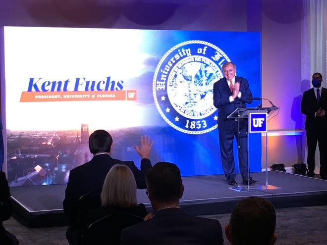 UF President Kent Fuchs announce the university's top-five ranking by U.S. News & World Report, and acknowledges a visit by Gov. Ron DeSantis, with his hand raised to wave back.