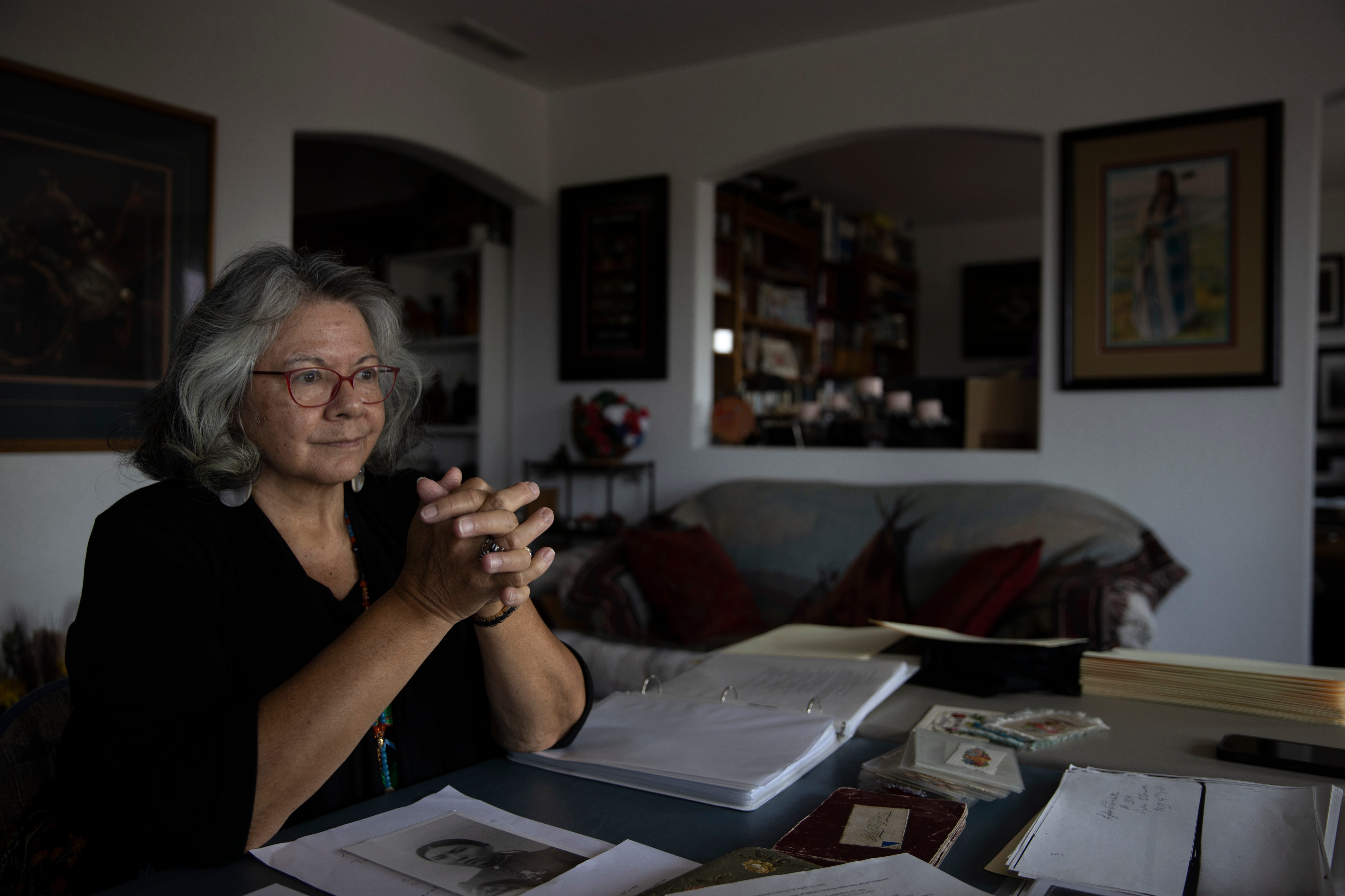 Dr. Robbie Paul looks over historical documents from Indian schools her relatives were at, in her home in Spokane, Washington, on Sept. 10.