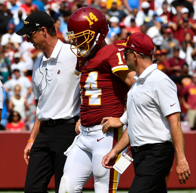 Washington Football Team QB Ryan Fitzpatrick leaves the pitch after injuring his hip Sunday against the Chargers.