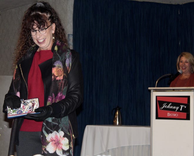Jane Stewart shows off a floral clutch matching her stylish jacket during a fashion show at Johnny T's Next Door in Hillsdale. [NANCY HASTINGS PHOTO]