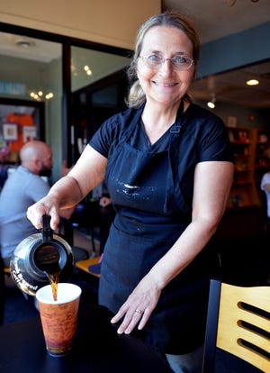 La propietaria de Coffee Haven, Pam Farrell, sirve una taza de café en su restaurante en Holliston.