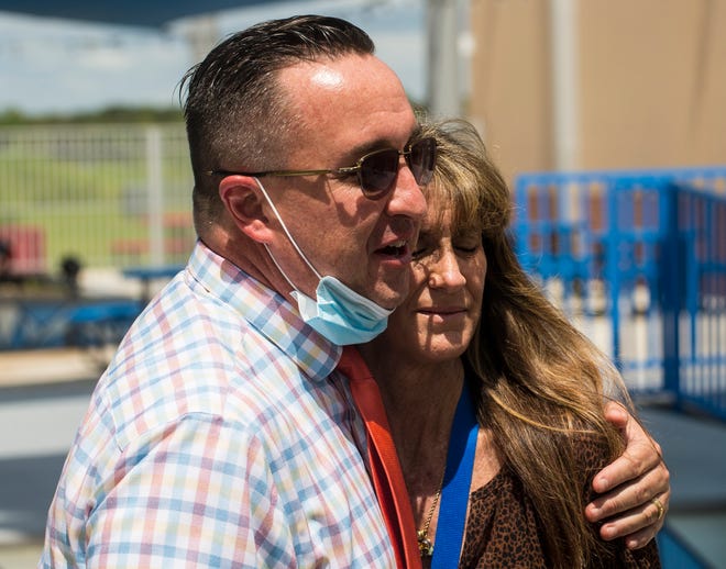 Harns Marsh Middle School Principal Alex Dworzanski gives a supportive embrace to testing coordinator Laura Davis after she spoke to the media at the school on Tuesday, September 14, 2021. She thwarted a possible school shooting by seeing something and saying something to school officials. Two students at the school were arrested charged with conspiracy to commit a mass shooting.