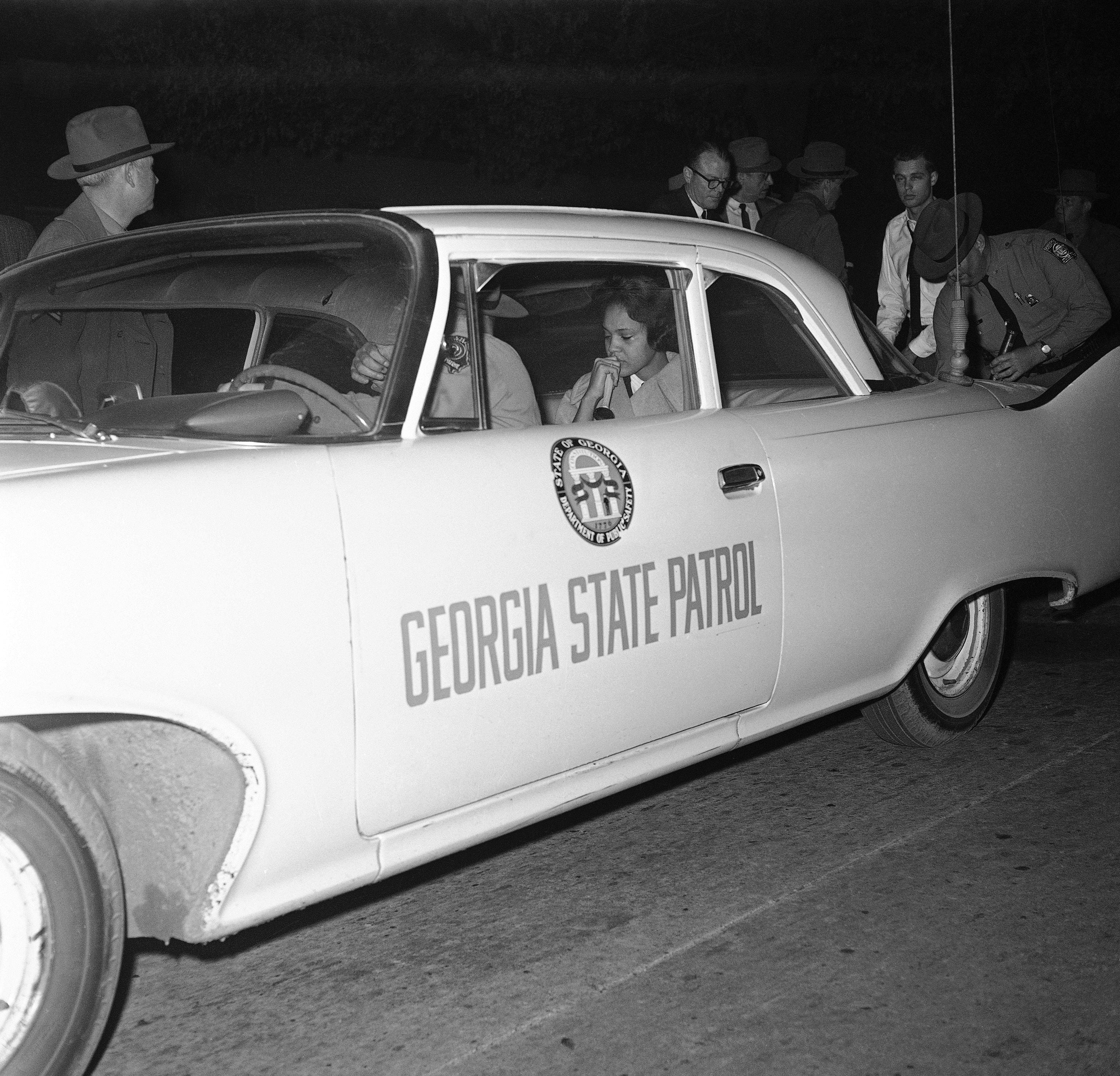 Charlayne Hunter, 18, who started classes at the University of Georgia under federal order, was escorted by a highway patrol officer for her own protection when students staged an uprising against the integration, Jan. 12, 1961.