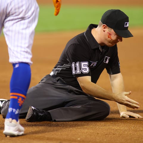 First base umpire Junior Valentine reacts after ge