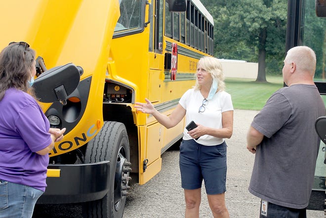 State Sen. Kim LaSata, center, talks with bus driver Trish Rea and mechanic Ron Yoder, during a visit to Three Rivers Community Schools to see the district’s electric buses.