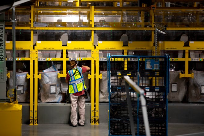 An Amazon employee helps with the package sorting process at the Amazon Air Hub at the Cincinnati/Northern Kentucky International Airport on Wednesday, Sept. 15, 2021, in Hebron, Ky. The Amazon hub will serve as the center of Amazon's U.S. air cargo operations.