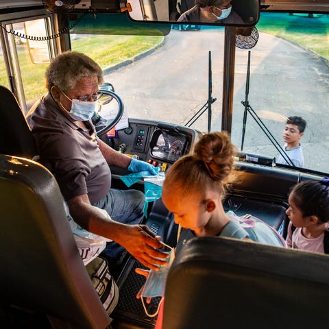 Des Moines school bus driver Jim Booker hands out 
