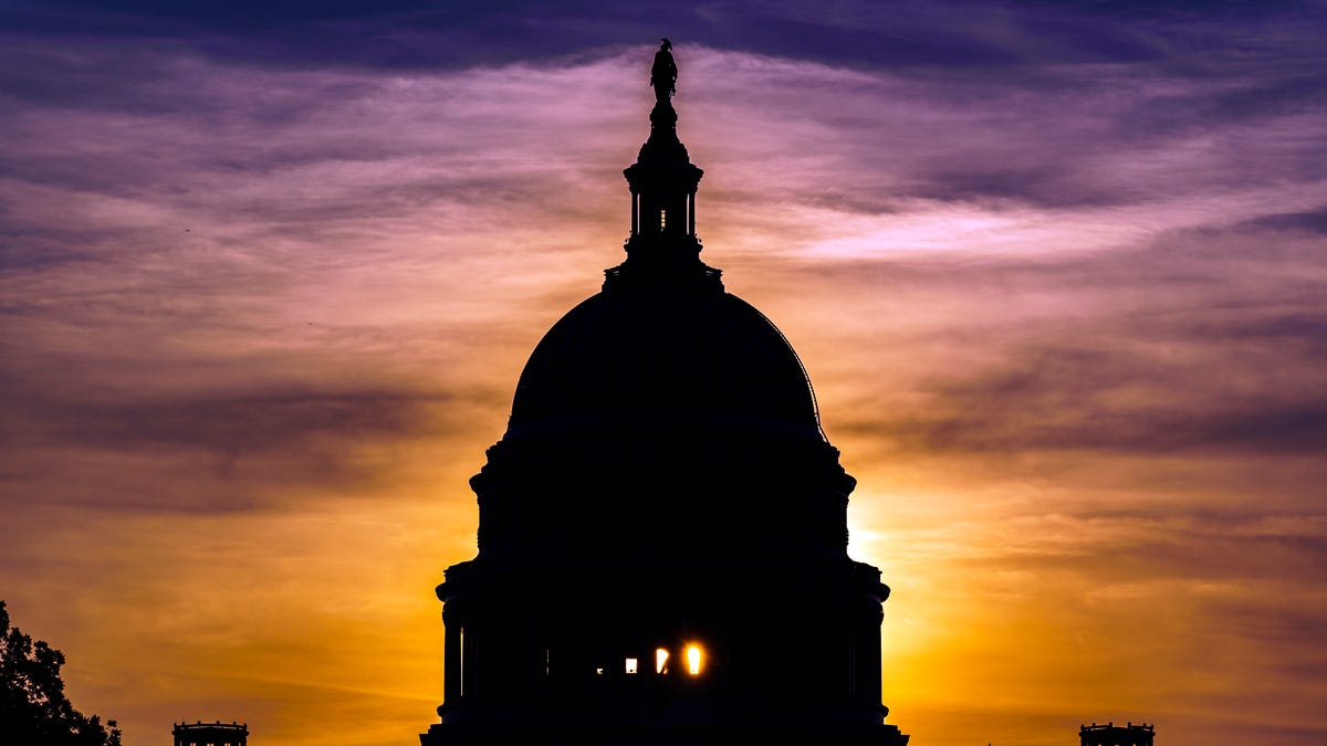 The sun rises behind the Capitol in Washington.
