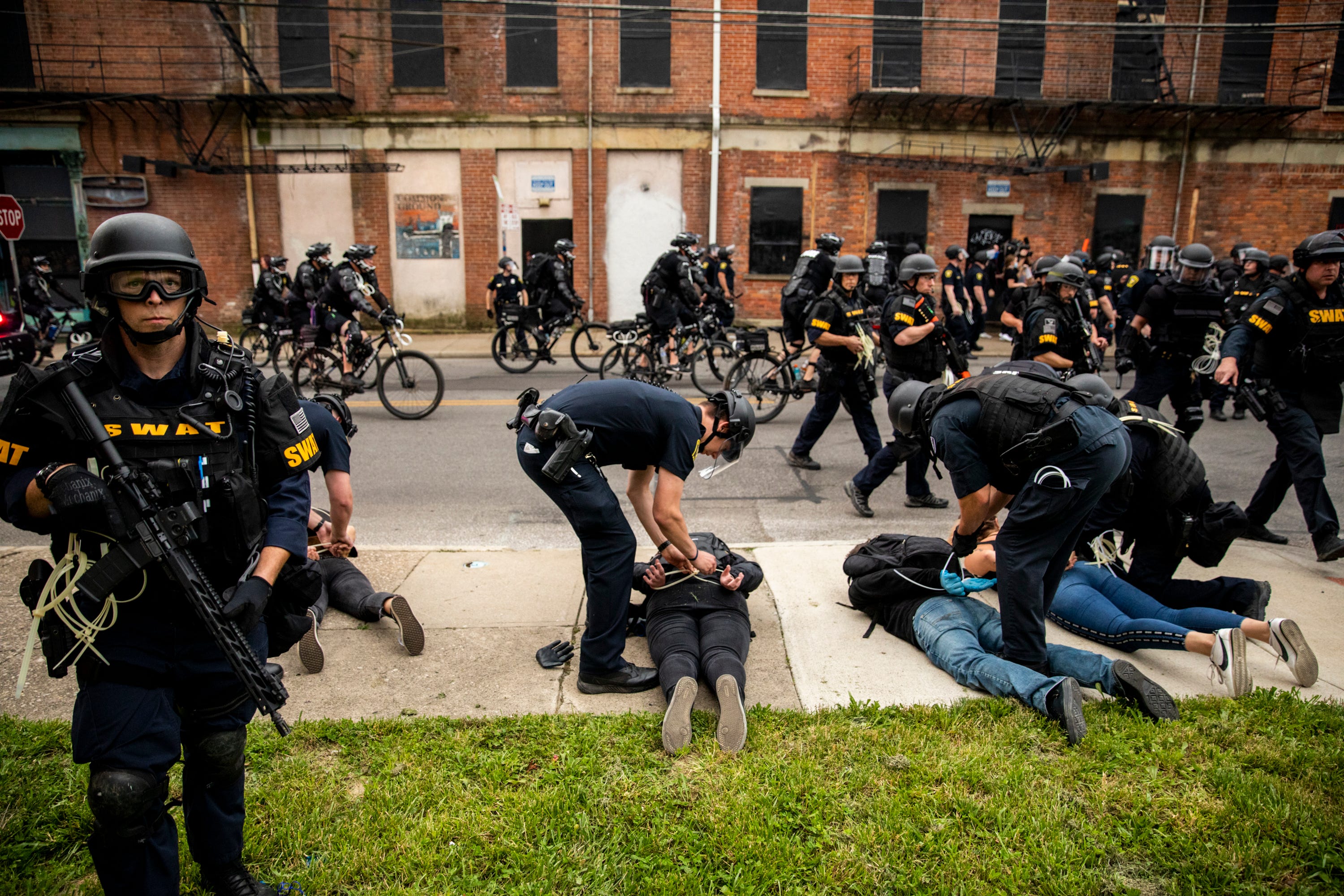 Cincinnati police officers arrest protesters on McMicken Stree after an 8 p.m. curfew on June 1, 2020, the fourth night of protests in response to the death of George Floyd in Minneapolis.