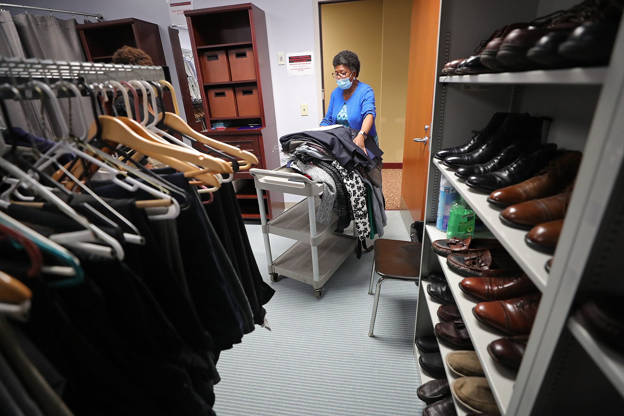 Alice Samuels wheels a cart of donated clothing to be sorted in the Career Clothing Closet at the Akron Urban League on Thursday.