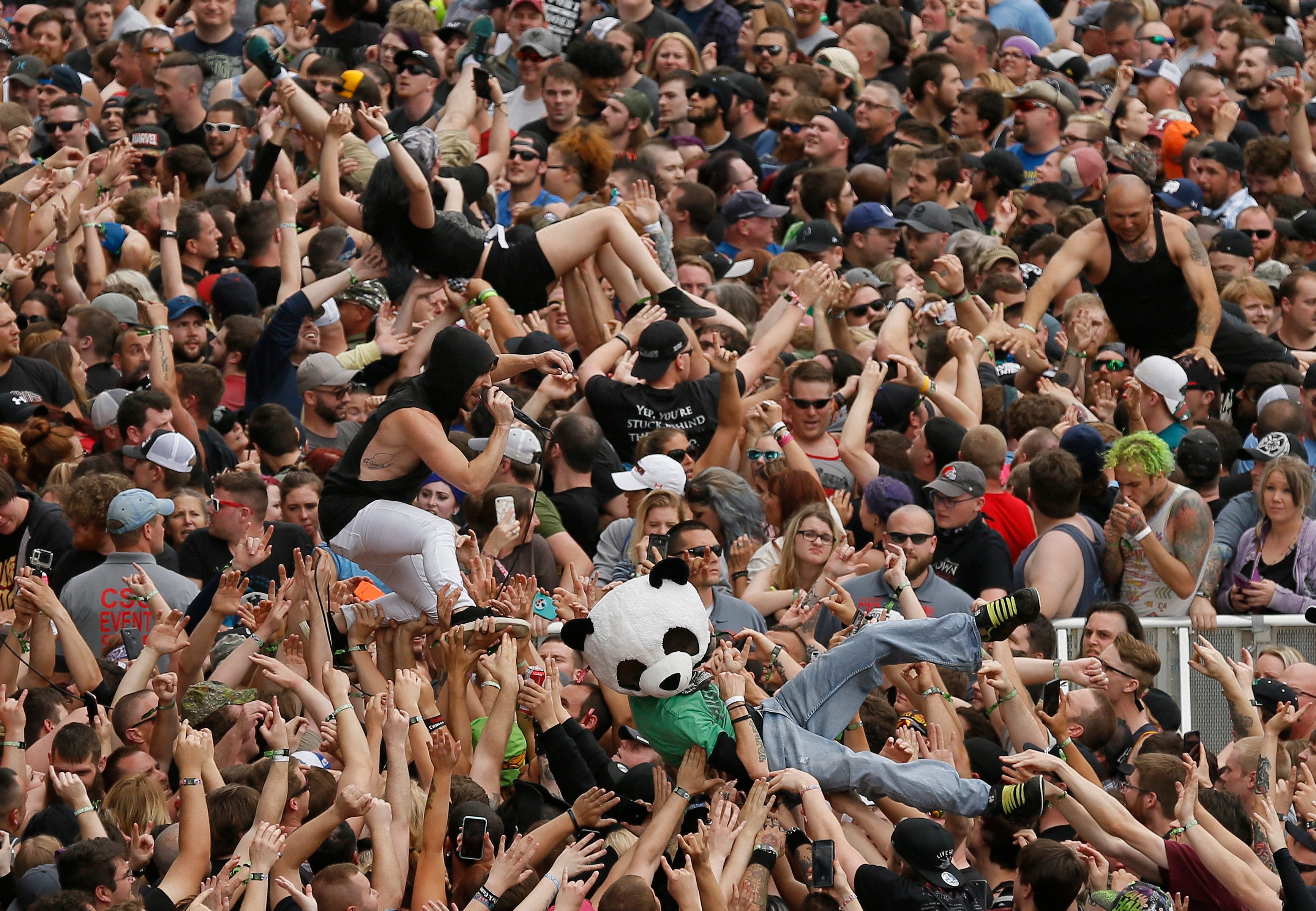 Concert attendees crowd-surf as 10 Years lead singer Jesse Hasek walks over the crowd at the Rock on the Range music festival in 2018. Crowded concerts today would pose some amount of risk for contracting COVID-19, health experts say.
