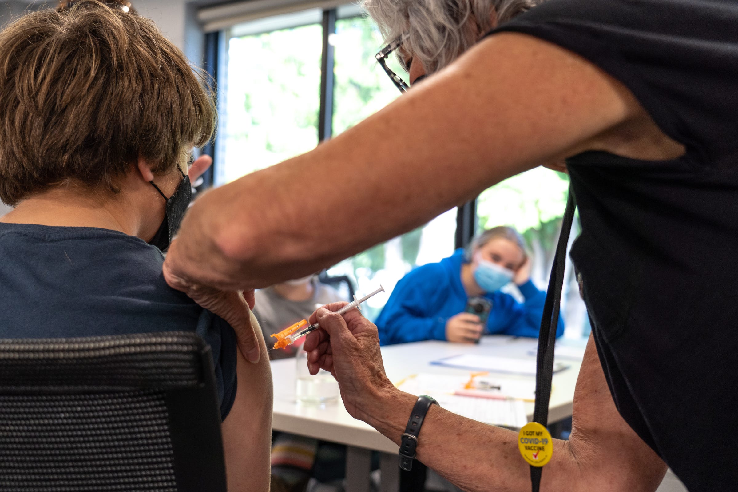 Benzie-Leelanau District Health Department retired women's health nurse practitioner Jan Frazee administers the first dose of the Pfizer Covid-19 vaccine to Nathan Warner during a community vaccination event at Northport Public School in Northport on Thursday, September 16, 2021.