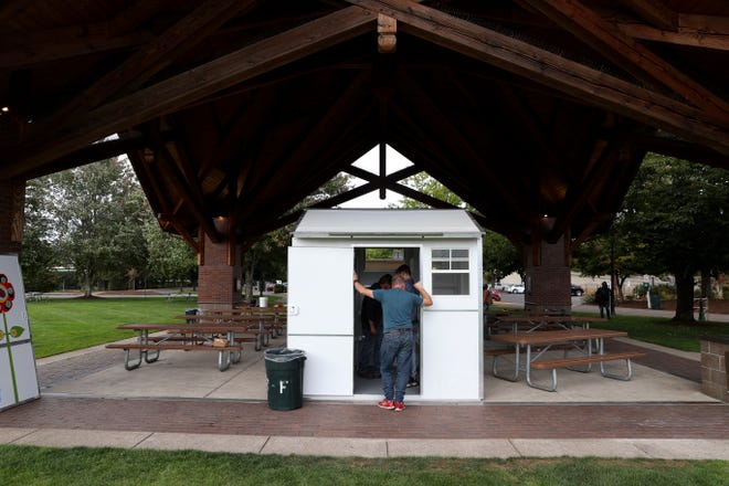 People view prefabricated transitional homes for houseless or unsheltered individuals at a pallet shelters sponsor event on Friday, Sept. 17, 2021.