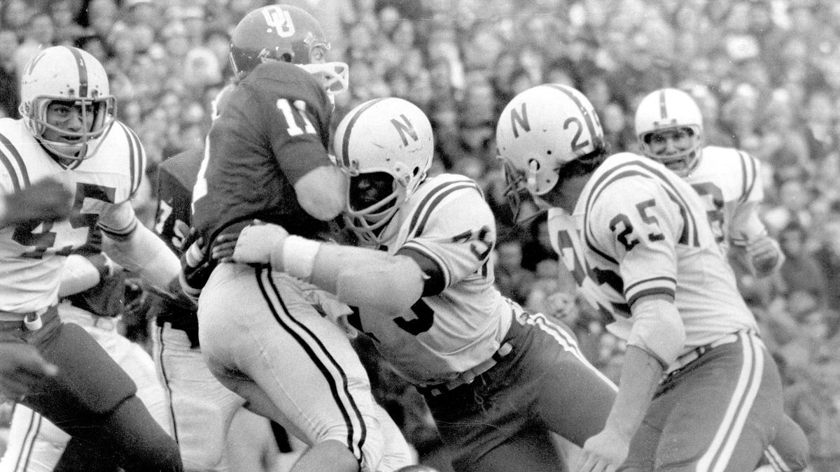 Nebraska's Rich Glover (79) brings down Oklahoma quarterback Jack Mildren (11) during their game in 1971 in Norman, Oklahoma.