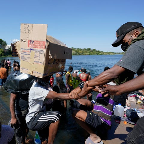 Haitian migrants use a dam to cross to and from th