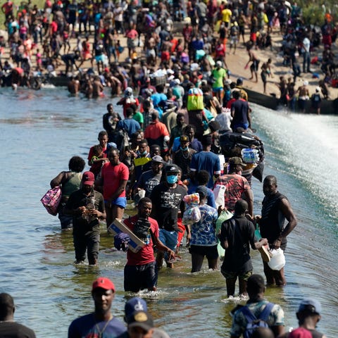 Haitian migrants use a dam to cross between the US