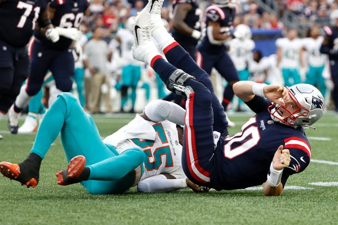New England Patriots quarterback Mac Jones (10) is brought down by Miami Dolphins outside linebacker Jerome Baker (55) during the Patriots' 17-16 loss in Foxborough, Mass.