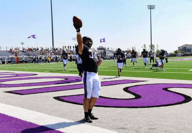 University of Sioux Falls' Thuro Reisdorfer holds the ball in victory after scoring a touchdown on Saturday, September 18, 2021, at Bob Young Field in Sioux Falls.