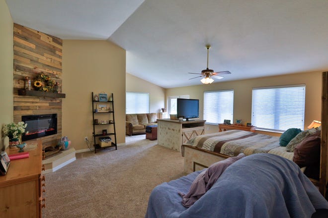 The split-bedroom, great-room floor plan offers two master suites, including this one with a sitting area and fireplace.