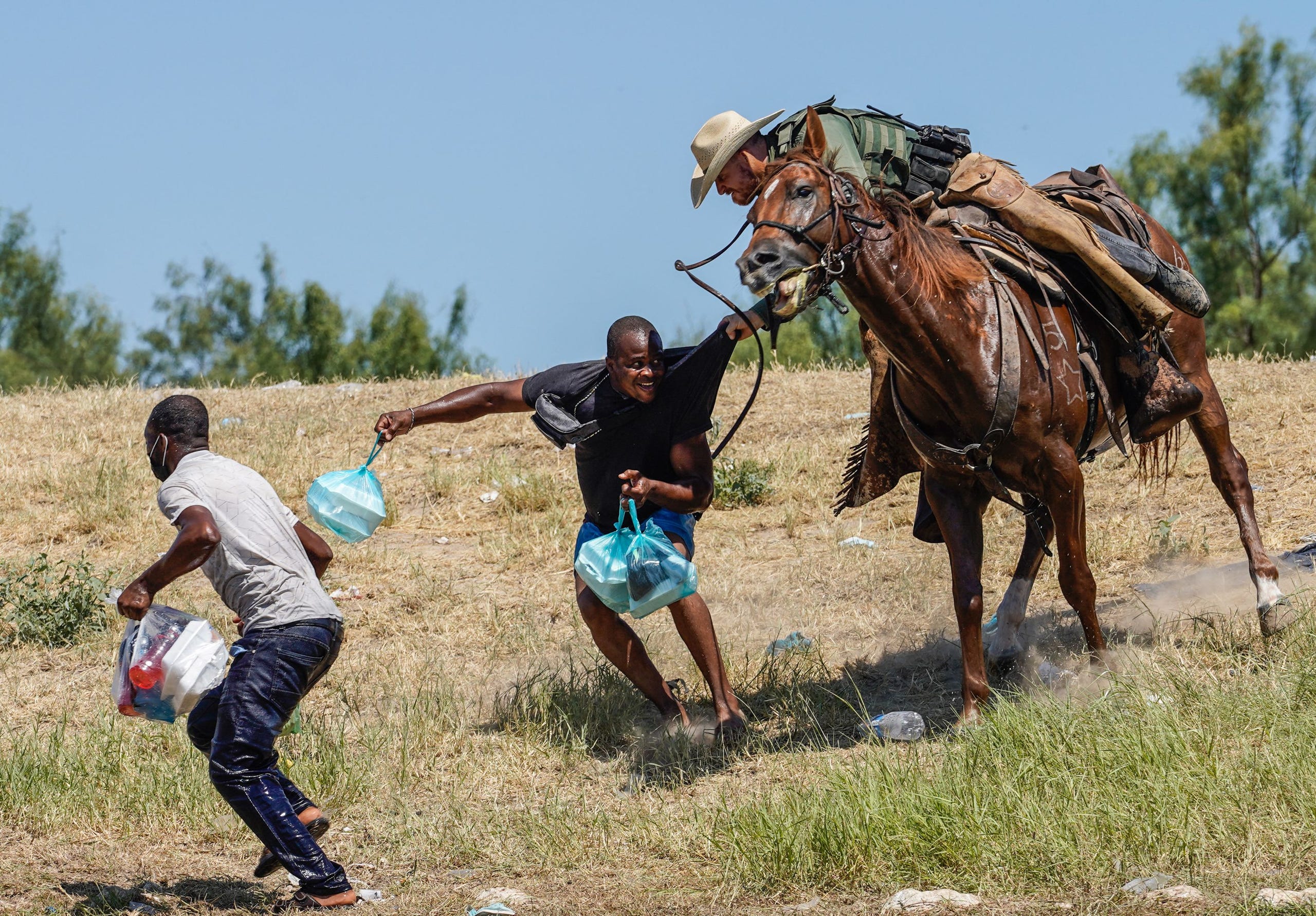A U.S. Customs and Border Patrol agent on horseback tries to stop a Haitian migrant from entering an encampment on the banks of the Rio Grande in Del Rio, Texas, on Sept. 19, 2021.