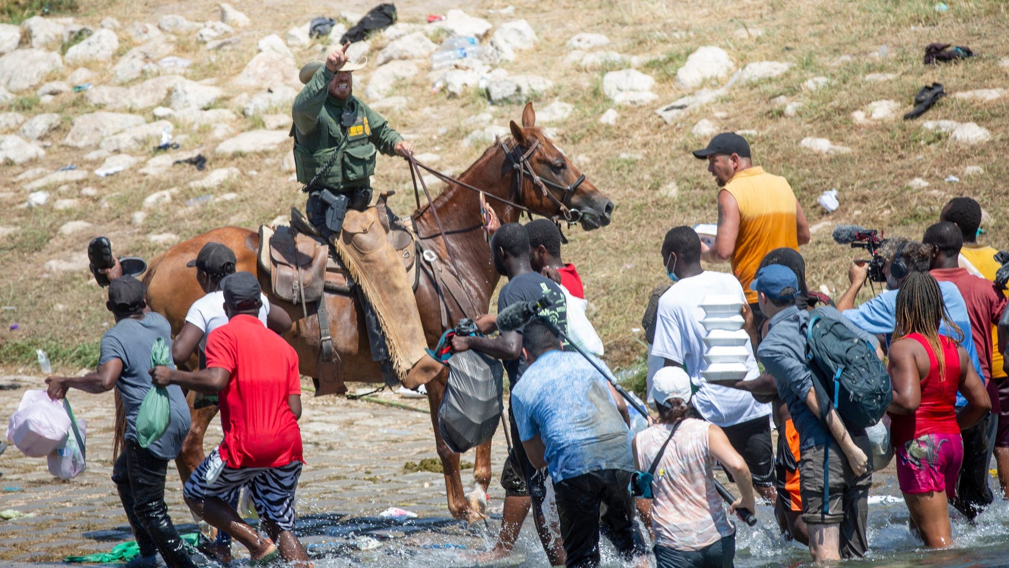U.S. Border Patrol agents deter Haitians from returning to the U.S. on the bank of the Rio Grande after migrants crossed back to Mexico for food and water on Sept. 19, 2021.