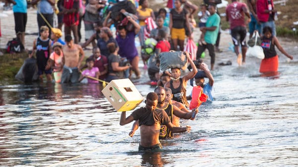 Haitian migrants cross the Rio Grande south into C