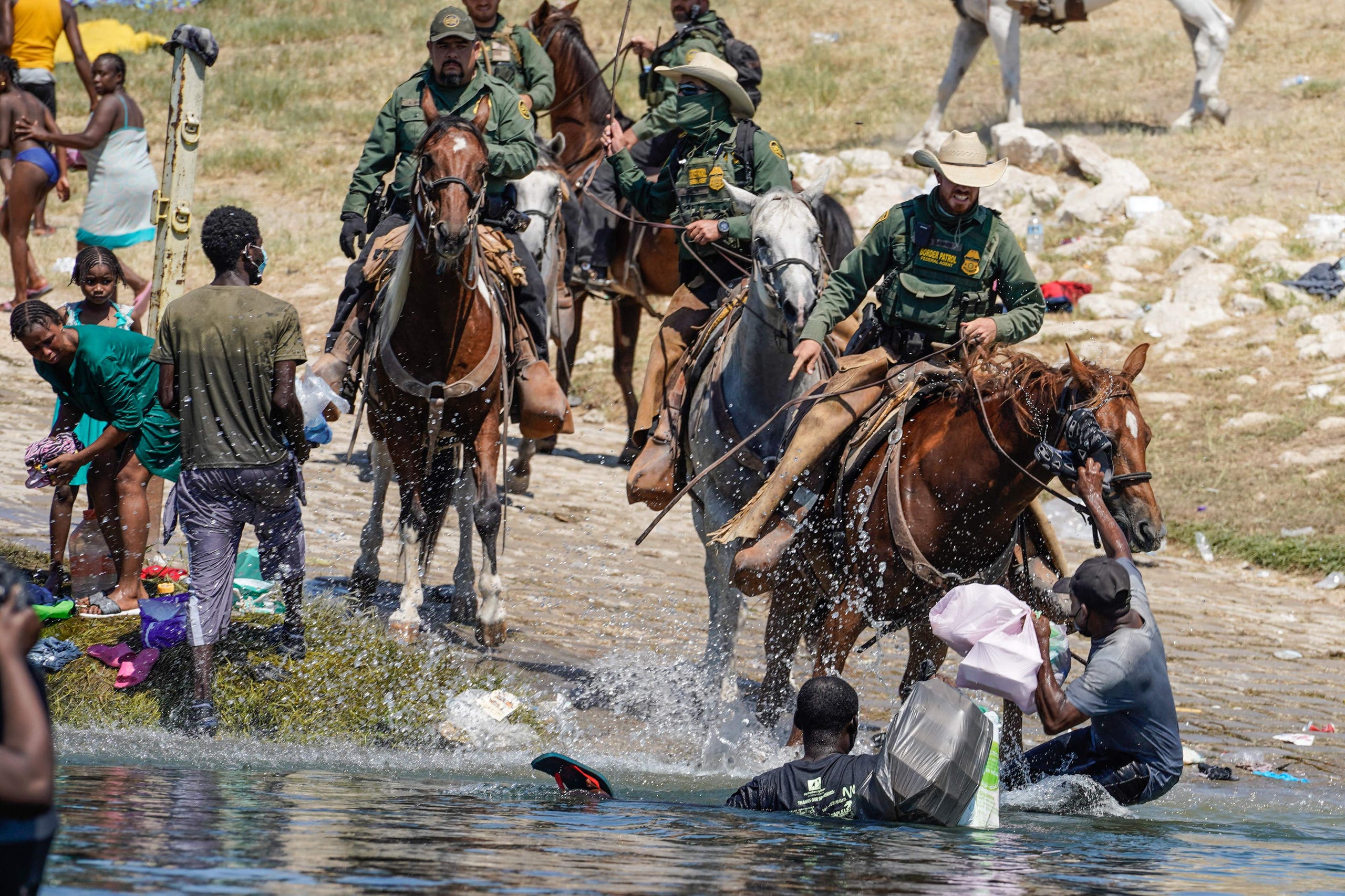 U.S. Customs and Border Patrol agents on horseback try to stop Haitian migrants from entering an encampment on the banks of the Rio Grande in Del Rio, Texas, on Sept. 19, 2021.