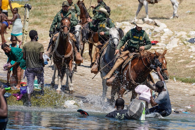 U.S. Customs and Border Patrol agents on horseback try to stop Haitian migrants from entering an encampment on the banks of the Rio Grande near the Acuna Del Rio International Bridge in Del Rio, Texas on Sept. 19, 2021.